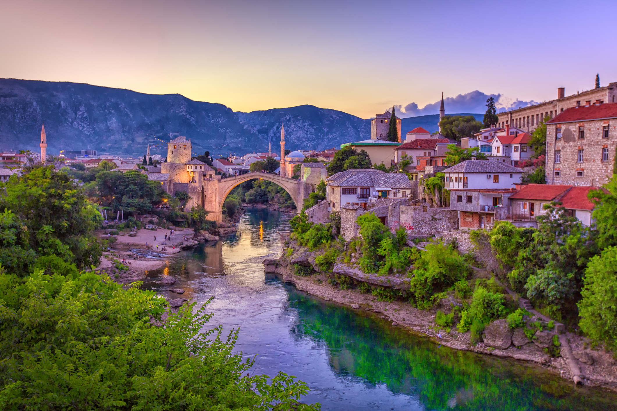 Stari Most spanning the Neretva River beside Mostar’s old town at sunset